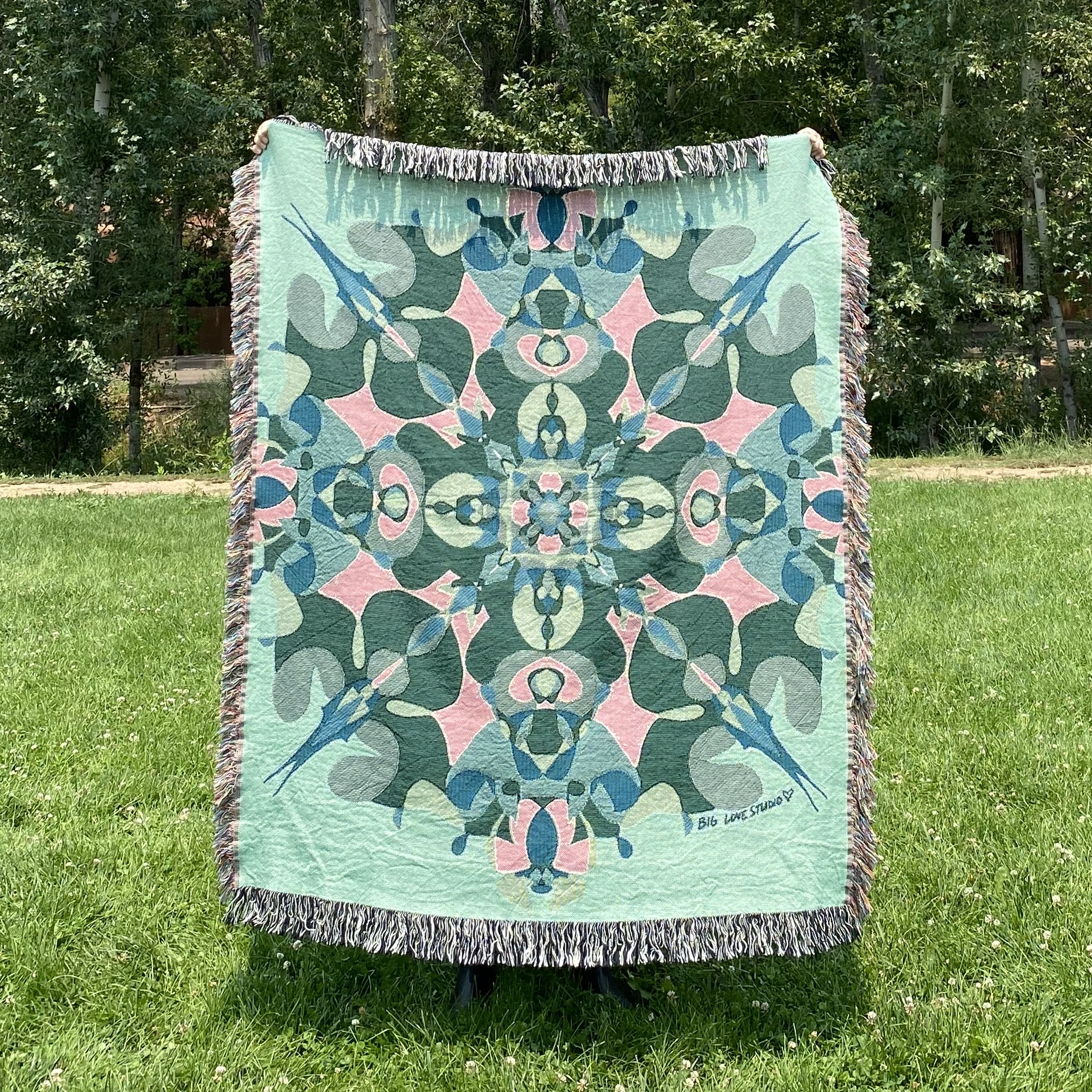 Green, blue, and pink kaleidoscope design woven blanket.
